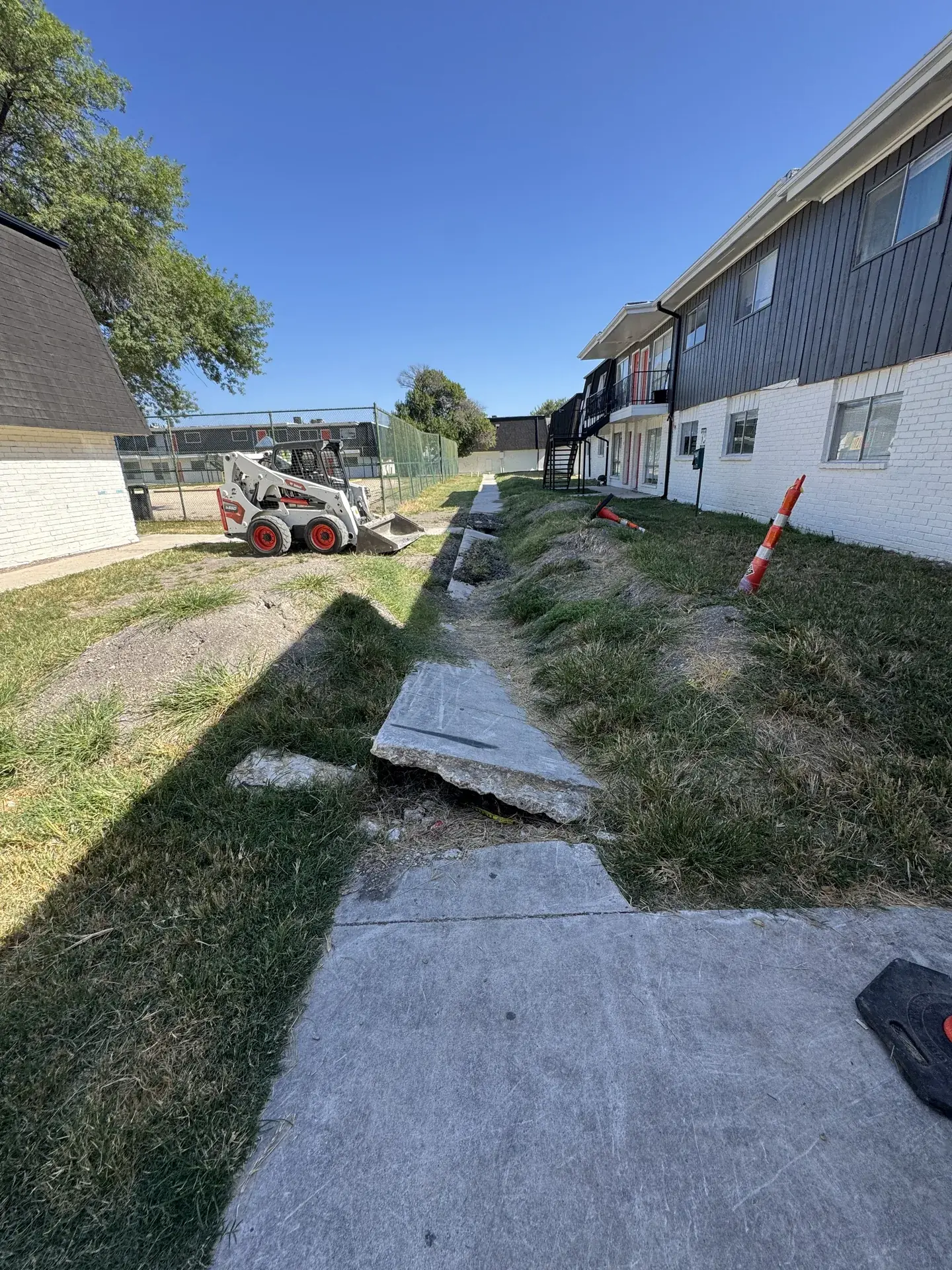 Five Star Trucking crew member saw cutting a concrete sidewalk along a San Antonio street