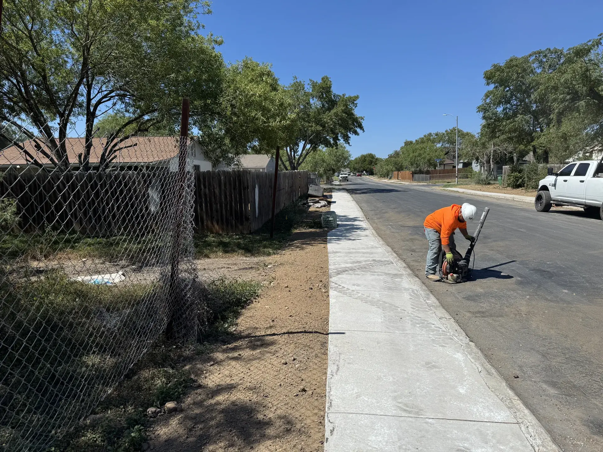 Five Star Trucking crew member saw cutting a concrete sidewalk along a San Antonio street
