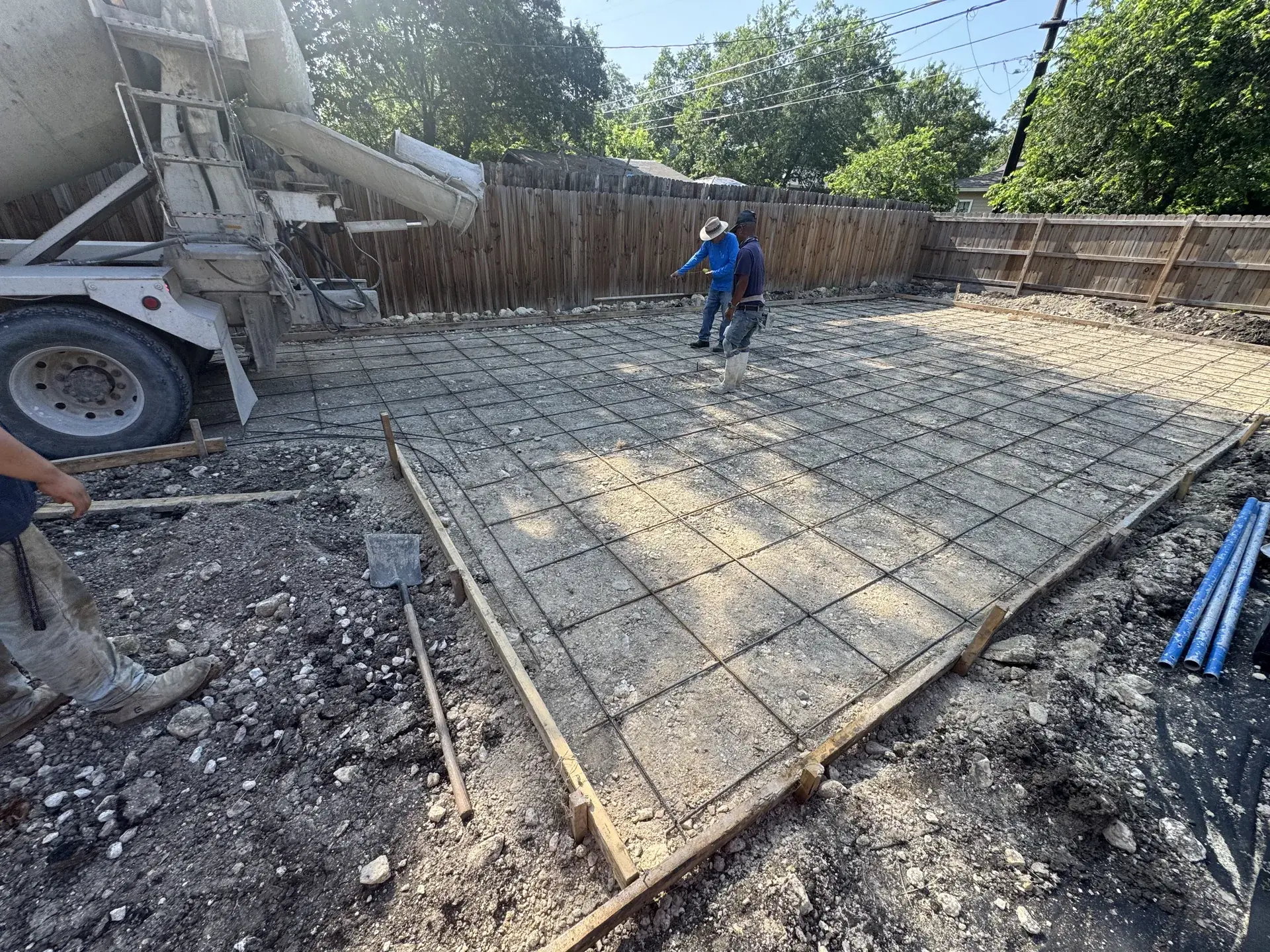 Concrete truck pouring a replacement slab in a San Antonio backyard after removal