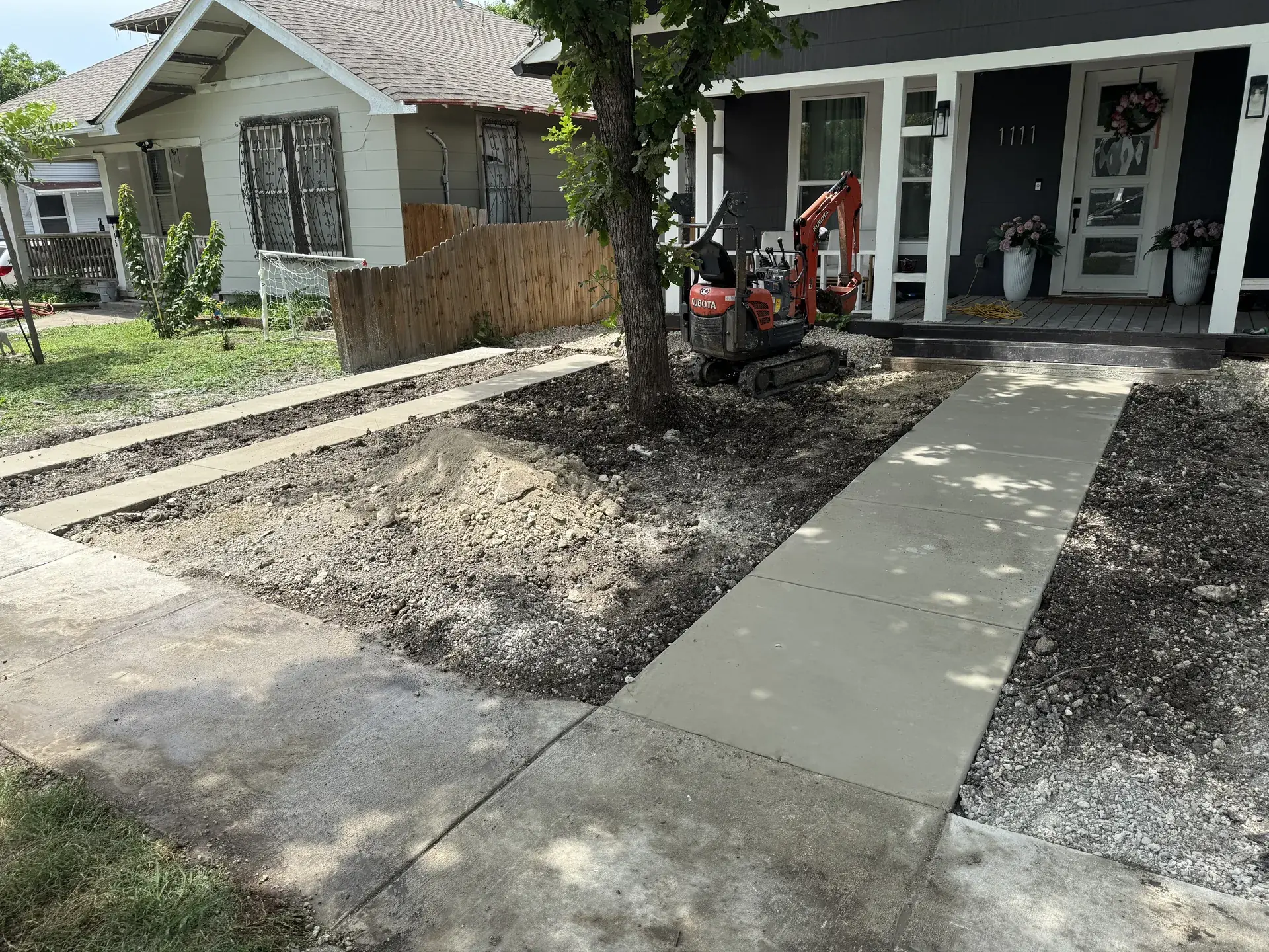 New front walkway in San Antonio with a mini excavator on site after concrete removal