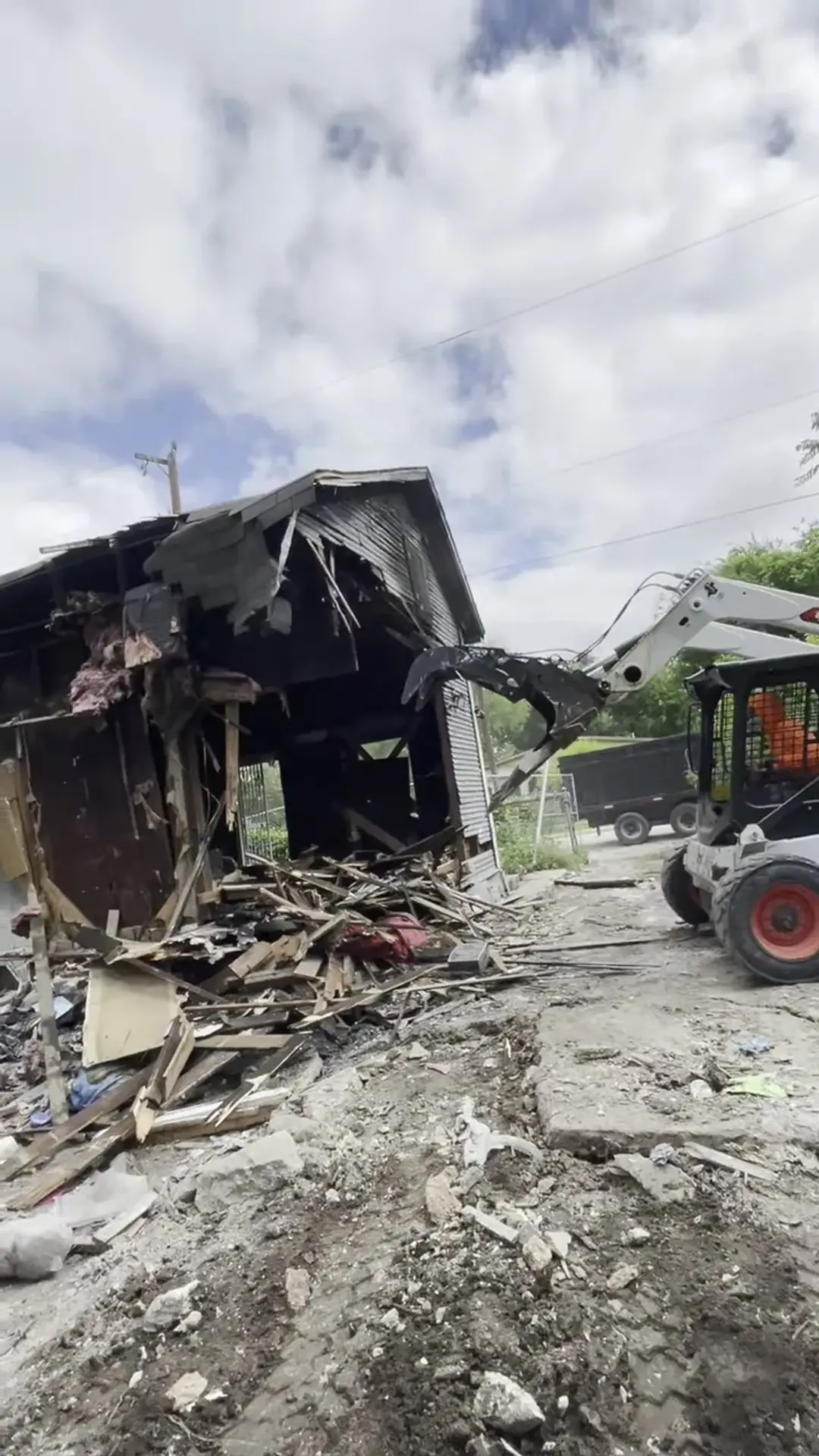 Five Star Trucking skid steer taking down the house