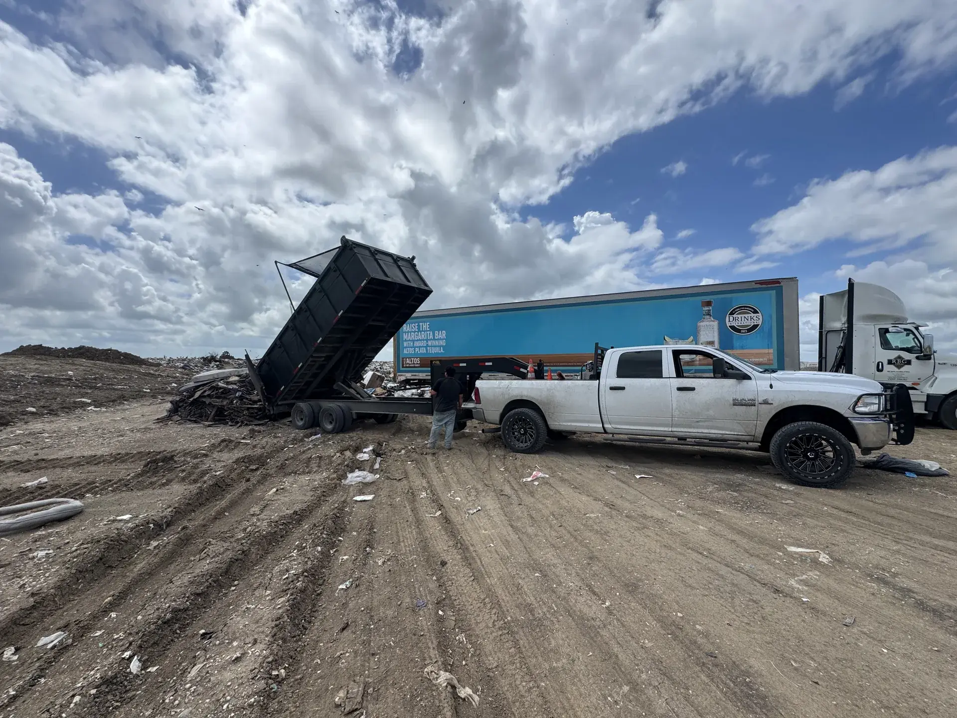 Hauling: Five Star Trucking pickup and dump trailer unloading debris at a San Antonio yard
